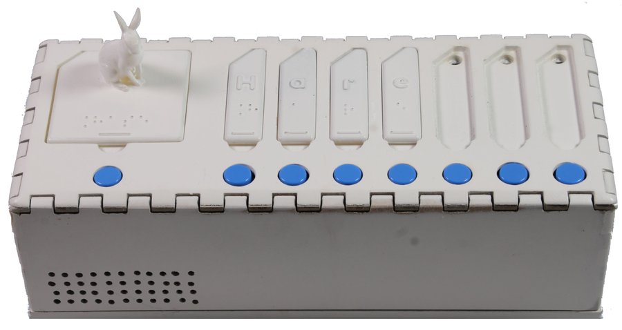 The BrailleBuddy device: a white tangible box with a 3D-printed rabbit figurine standing on a large word card, four letter cards spelling the German word Hase with embossed letters and Braille dots, three empty card slots, a row of round blue buttons and a speaker grille on the front.